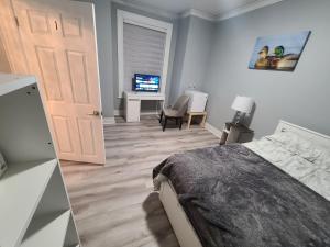 a bedroom with a bed and a desk and a television at Spacious room in downtown Ottawa. Room #1 in Ottawa