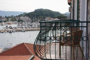 a balcony with a chair and a view of a harbor at Hotel RR in Herceg-Novi