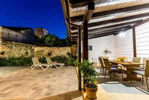 een patio met een tafel en stoelen bij CASA MARIO-charming stone house with jacuzzi in Svetvinčenat