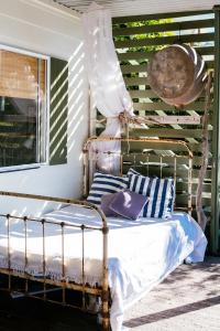 an old bed on a porch with striped pillows at Hillhouse in Point Lookout