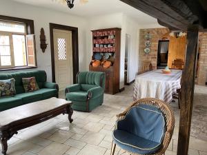 ein Wohnzimmer mit grünen Möbeln und einem Tisch in der Unterkunft Casa das Andorinhas - Campo e Piscina 