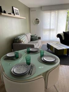 uma sala de estar com uma mesa com pratos em Appartement proche Paris & Orly em Chevilly-Larue