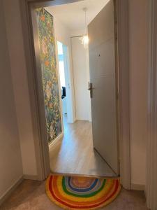 een hal met een deur en een kleurrijk tapijt bij Appartement proche Paris & Orly in Chevilly-Larue
