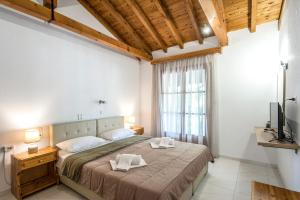 a bedroom with a large bed and a window at ELIZA Skiathos in Skiathos Town
