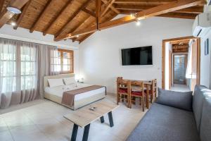 a bedroom with a bed and a couch and a table at ELIZA Skiathos in Skiathos Town