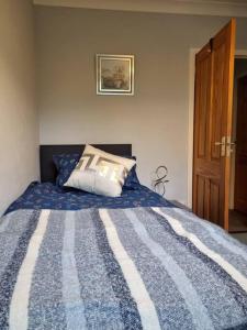 a bedroom with a bed with a blue and white comforter at Shunters Cottage in Darnick