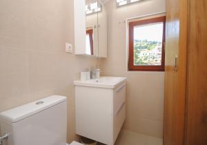 a bathroom with a toilet and a sink and a window at Apartments Dilk in Vis