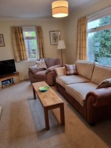 Sala de estar con 2 sofás y mesa de centro en Shunters Cottage en Darnick
