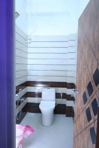 een badkamer met een wit toilet in een kamer bij CHANDRODAYAM RESIDENCY in Kāraikāl