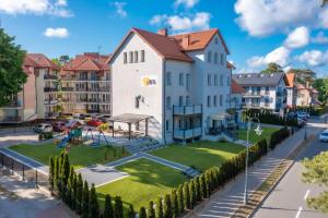 a large white house with a playground in a city at Dom Wypoczynkowy Rena in Krynica Morska