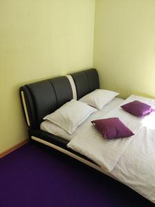 a bed with purple pillows on it in a room at Bluci seksti in Seksti