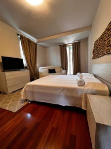 1 dormitorio con 1 cama grande y TV en Charm Casa Fabiale, en Garda