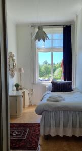1 dormitorio con cama y ventana grande en Hotell Örnen, en Torsby