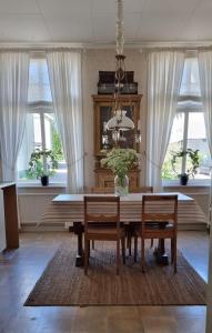 a dining room with a table and chairs and windows at Hotell Örnen in Torsby