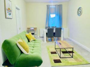 - un salon avec un canapé vert et une table dans l'établissement Darlington City Flat, à Darlington