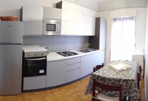 a kitchen with white cabinets and a table with a table cloth at Villetta Aurora in Lipari +10 photos