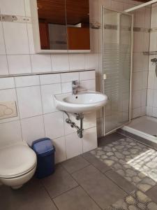 a bathroom with a sink and a toilet at Gästehaus Terrana in Wathlingen