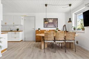 cocina y comedor con mesa y sillas en House near public transport, en Lystrup