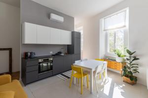 a kitchen with a white table and yellow chairs at Lago Design Guest House - Como Center in Como
