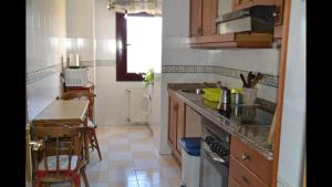eine Küche mit einer Theke, einem Tisch und einem Waschbecken in der Unterkunft El Descanso in Oviedo