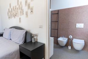 a bedroom with a bed and a bathroom with a toilet at Lago Design Guest House - Como Center in Como
