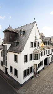 ein großes weißes Gebäude mit braunem Dach in der Unterkunft Ringhotel Central - Superior in Rüdesheim am Rhein