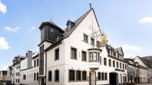 ein weißes Gebäude mit einem Uhrturm oben drauf in der Unterkunft Ringhotel Central - Superior in Rüdesheim am Rhein