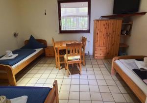 a room with two beds and a table and chairs at Gästehaus Terrana in Wathlingen