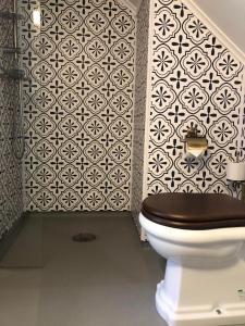 a toilet in a bathroom with a black and white wall at Jaunsen Gjestgjevarstad in Granvin