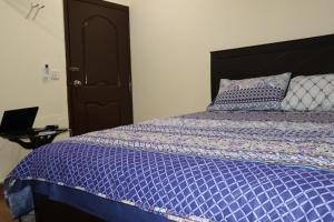 um quarto com uma cama com um edredão roxo em QB Elegant Villa with Valley View em Rawalpindi