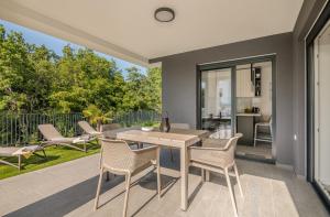 a dining room with a table and chairs on a patio at Apartment Manuela in Njivice