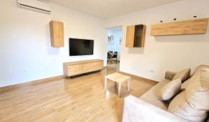 Una sala de estar con un sofá y un televisor de pantalla plana. en Villa Candari, en Chiclana de la Frontera