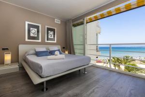 a bedroom with a bed with a view of the beach at GLAM ONLY FAMILIES Planet Costa Dorada in Salou