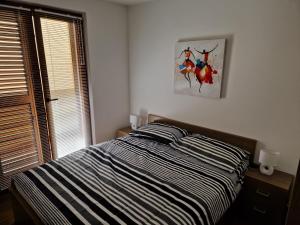 een slaapkamer met een bed en een schilderij aan de muur bij S + A in Posedarje +35 foto's