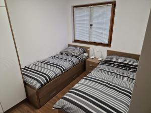 two beds in a small room with a window at S + A in Posedarje