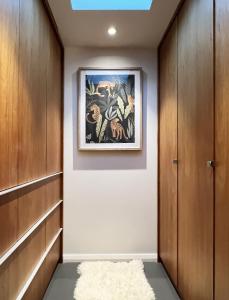 a hallway with wooden cabinets and a painting on the wall at Cosy Cottage 2 Bedroom Great Location Close to Transport in Sydney