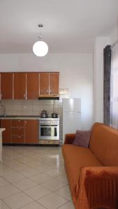 a living room with a couch and a kitchen at Deni's Family Apartment in New BLVD in Tirana