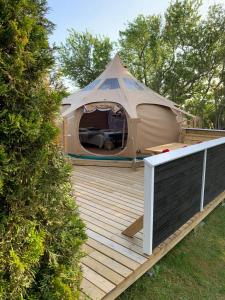 ein Zelt auf einer Holzterrasse im Hof in der Unterkunft Romantic Luxus Glamping 3 in Idestrup
