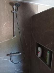 La salle de bains est pourvue d'une douche avec un pommeau de douche. dans l'établissement Vakantie appartement de Havezate, à Roden