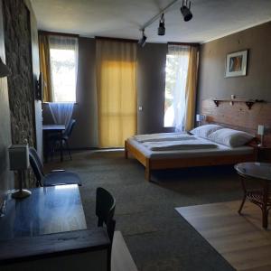 um quarto com uma cama, uma mesa e cadeiras em Villa Sagan em Zamárdi