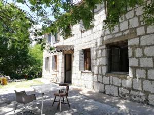 a table and chairs in front of a stone building at Leppo Guest House in Gacko