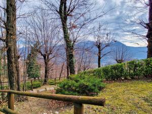 una valla de madera con árboles y montañas en el fondo en La Breva apt. Lake Como Bellagio, en Magreglio