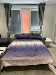 a bedroom with a large bed and a couch at Roof Garden Flat in London