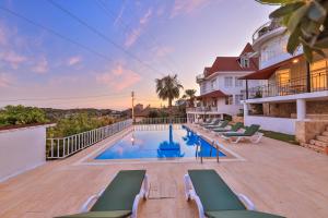 a swimming pool with chaise lounge chairs next to a house at 3 House Apart in Kas