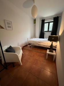 ein Schlafzimmer mit einem Bett, einem Stuhl und einer Lampe in der Unterkunft Casa Mimose Rosa in SantʼAngelo in Pontano
