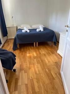 a bedroom with a bed with blue sheets and a wooden floor at Apartment in Åsane in Bergen