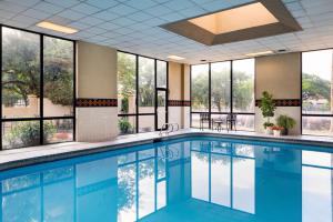 a swimming pool in a hotel lobby with windows at Houston Marriott South at Hobby Airport in Houston