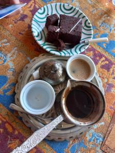 a plate with a piece of cake and two cups of coffee at Accordeon in Visoko