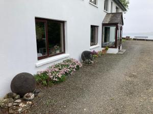 a white house with flowers outside of it at Dromcloc House in Bantry