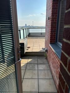 a door to a balcony with a view of the water at Roof Garden Flat in London